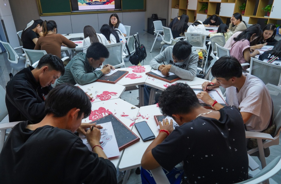 【图4】中外学子围坐长桌,在非遗指导老师示范下进行金坛刻纸创作